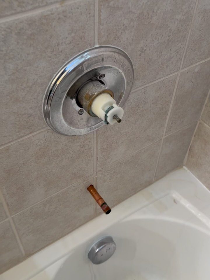 Before: worn shower trim with a missing handle and a stub of copper where the spout was