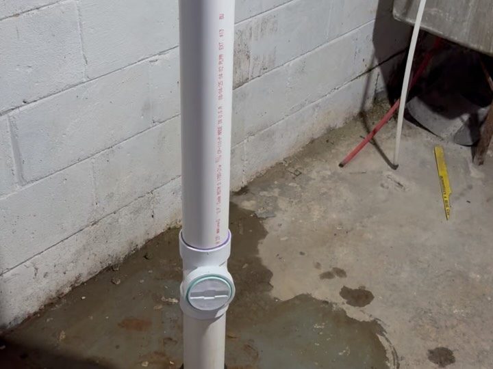 After: a new white PVC drain stack in a basement